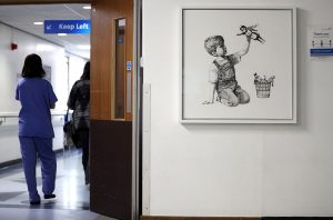 A person walks past the new artwork painted by Banksy during lockdown, entitled 'Game Changer', which has gone on display to staff and patients on Level C of Southampton General Hospital. (Photo by Andrew Matthews/PA Images via Getty Images)