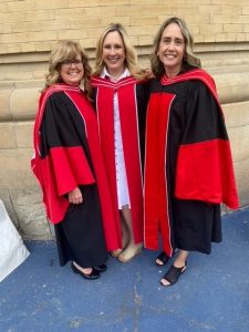 Image of three people with red and black robes