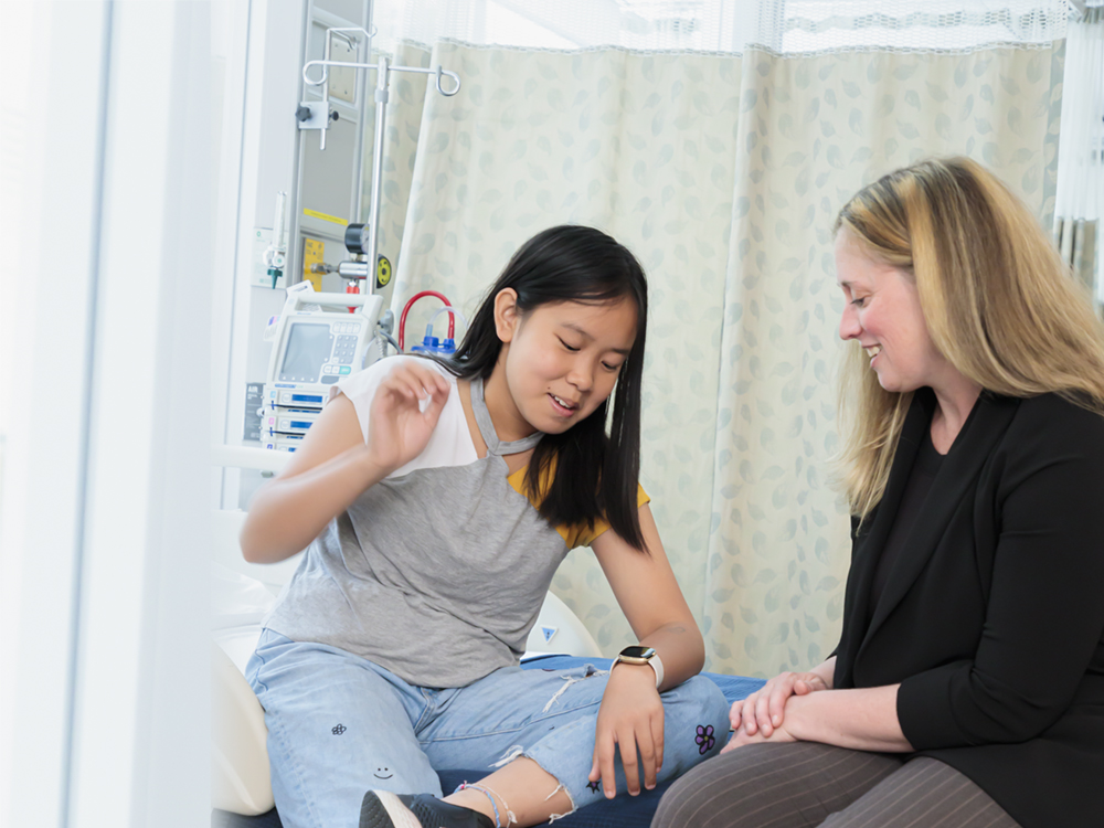 Young girl looks at watch while researcher looks on